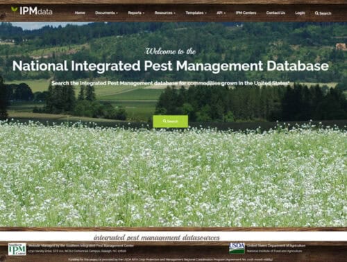 Homepage of the National Integrated Pest Management Database featuring a scenic landscape with fields and mountains, designed for searching pest management information for U.S. commodities.